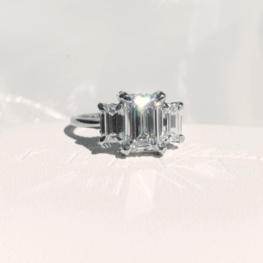 Trilogy Emerald cut Diamond Engagement Ring with infinity hidden halo.
